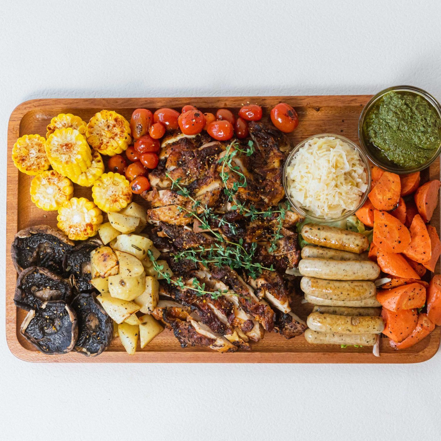 Rustic grilled chicken thigh and sausage platter for sharing, ideal for parties in Singapore